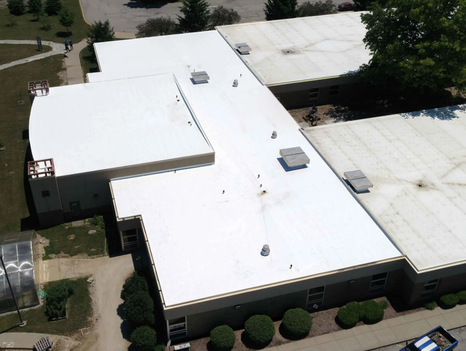 Aerial view of an educational facility with a coated roof